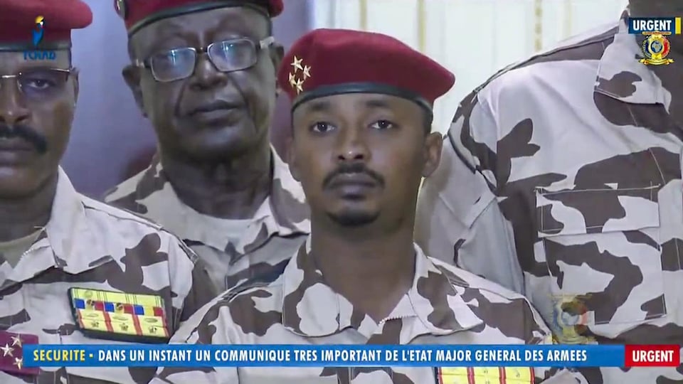 A young man in military uniform surrounded by other soldiers.