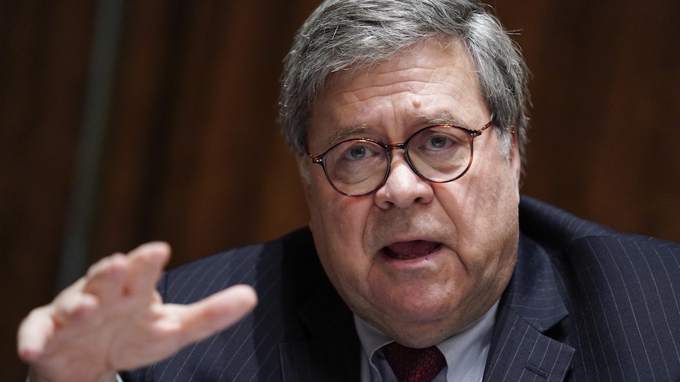 William Barr speaks with his hand outstretched in front of him.