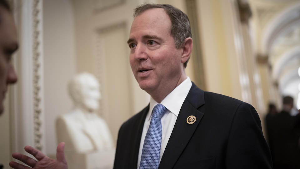 Adam Schiff speaking in front of a white marble statue. 