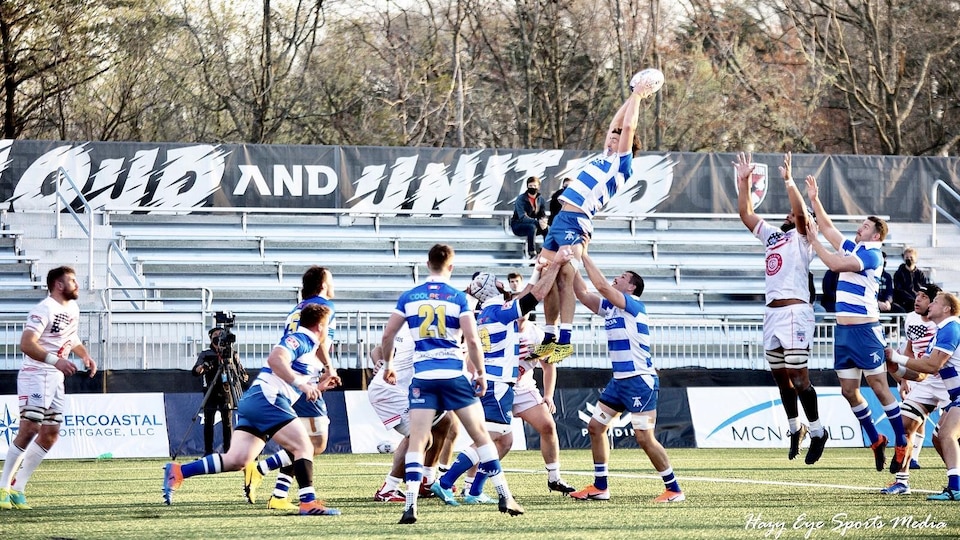 An arrow player catches a ball in the air during a throw.