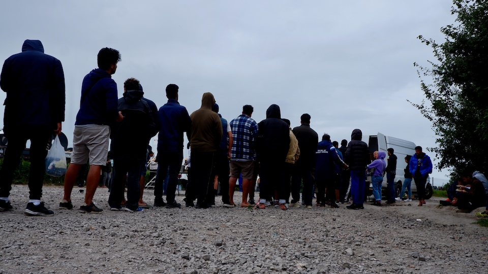 People queuing participate in the distribution of meals.