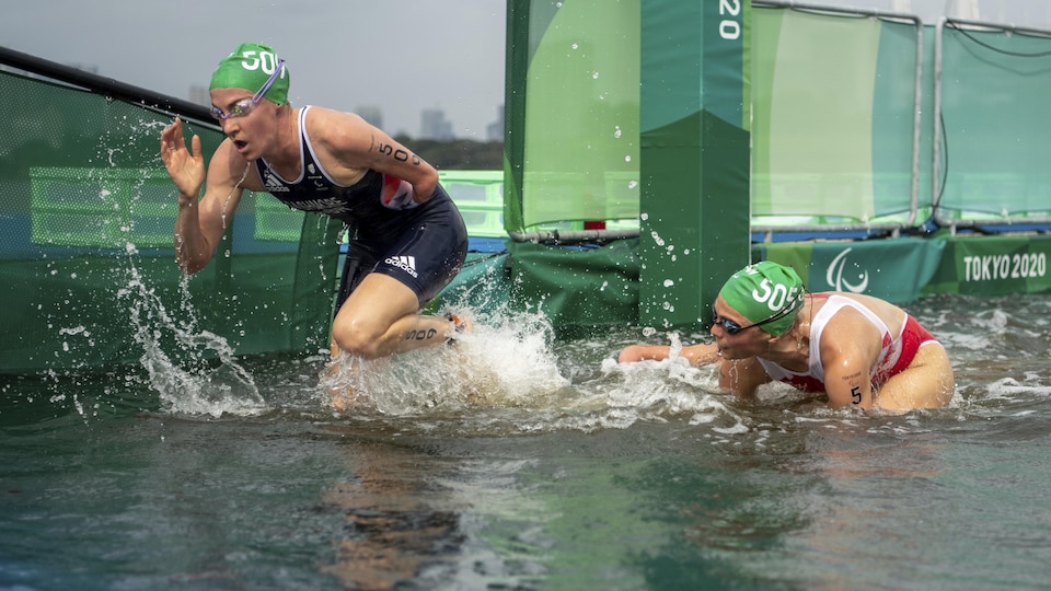 Britain's Claire Cashmore and Canada's Camille Frenett emerge from the water before the cycling portion of the Paratriathlon Games begins.