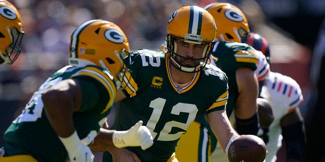 Green Bay Packers quarterback Aaron Rodgers (12) passes the ball back to AJ Dillon during the first half on October 17, 2021 in Chicago.