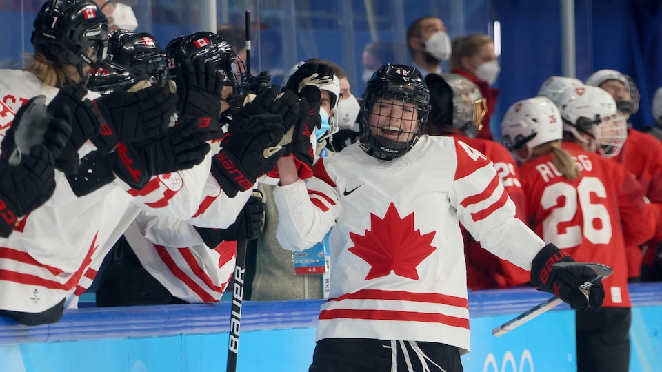 She taps her teammates' glove as she passes the bench.