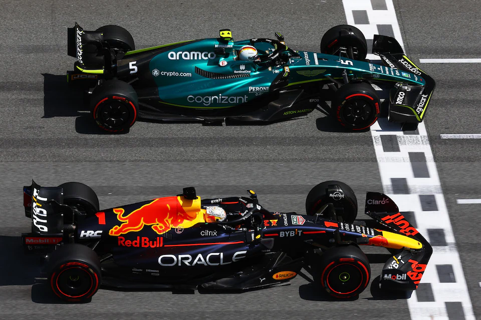 Two F1 singles drive side by side in a circuit.