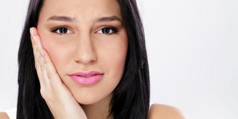 Young woman suffering from toothache