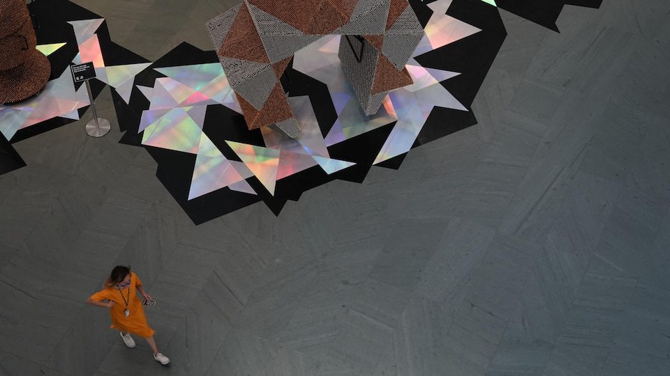 A woman walking alone in the lobby of the Museum.