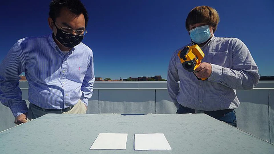 The researchers use an infrared camera to compare the cooling performance of samples of white paint on a surface.